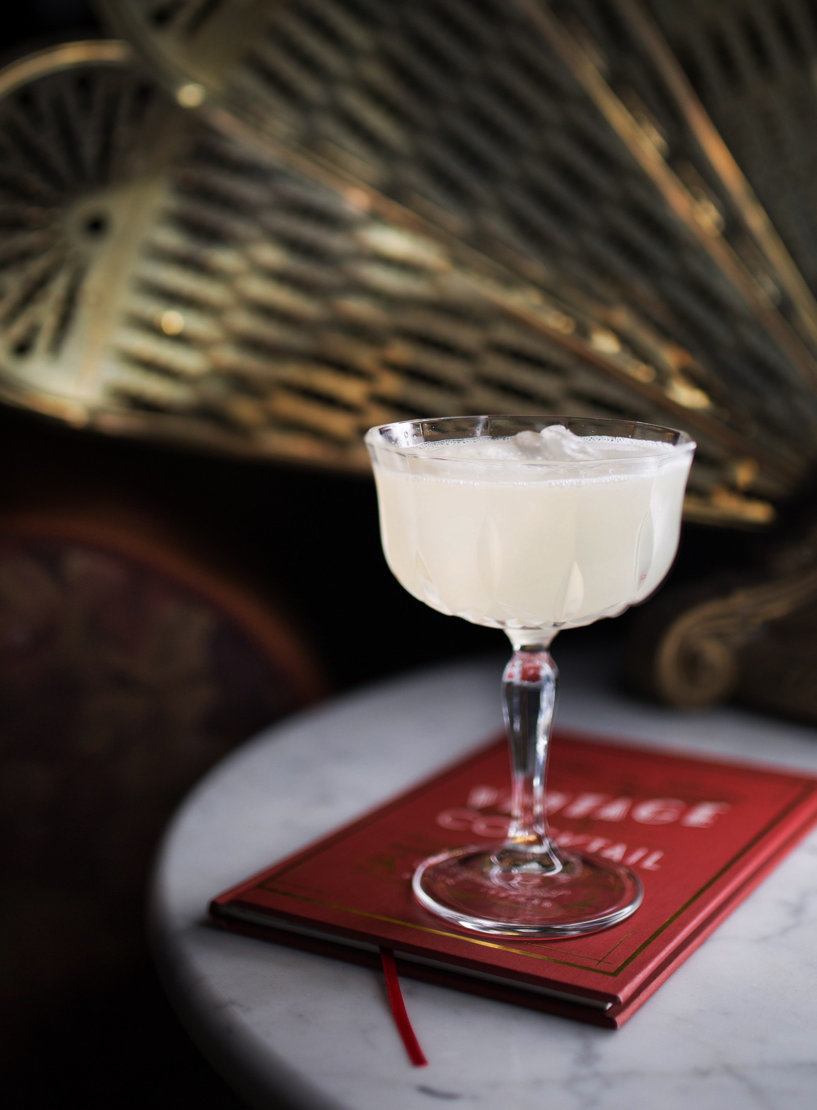 A classic cocktail resting on the red VCC menu